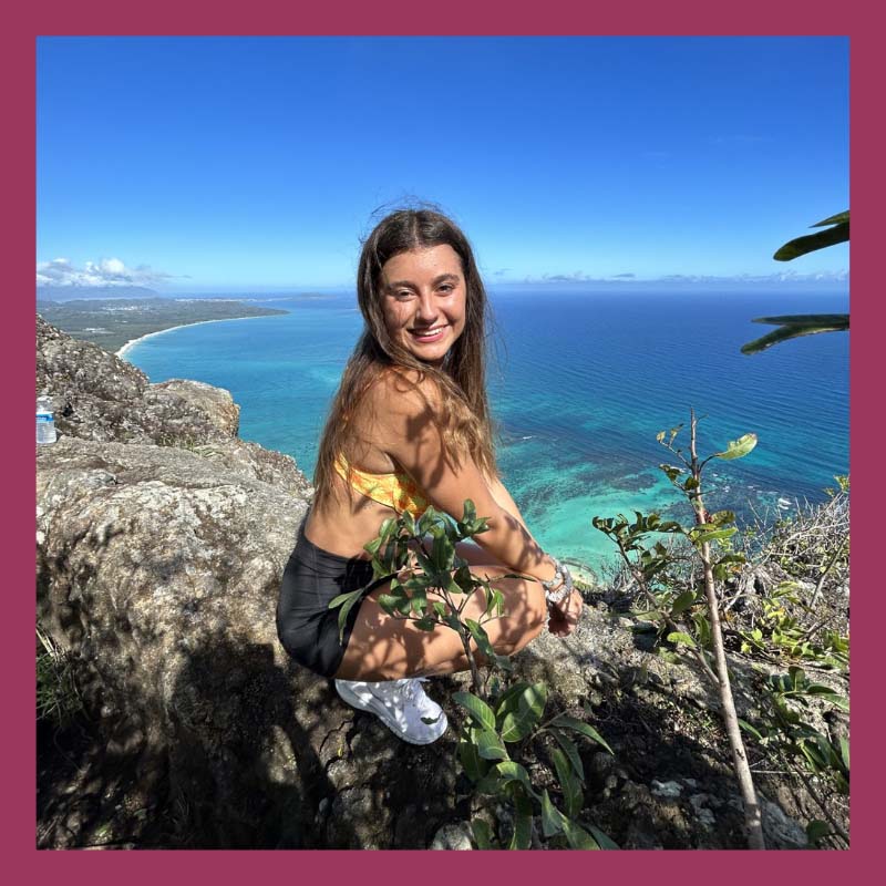 Kaylie posing on a cliff overlooking the ocean