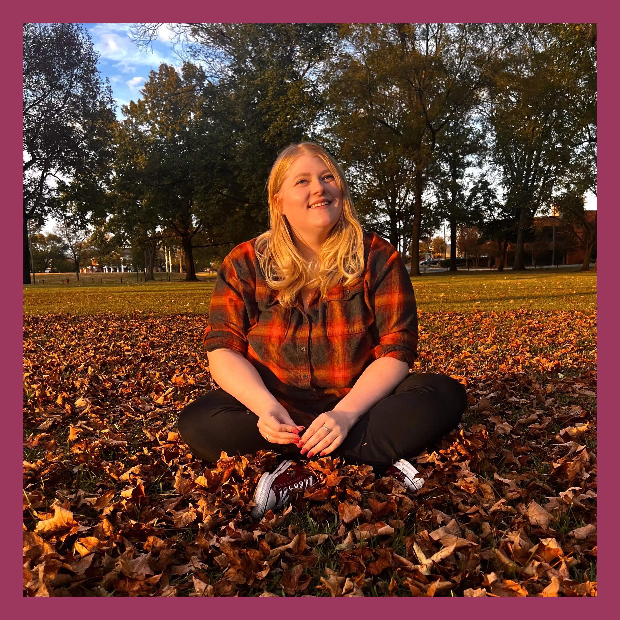 Samantha sitting amongst fallen autumn leaves