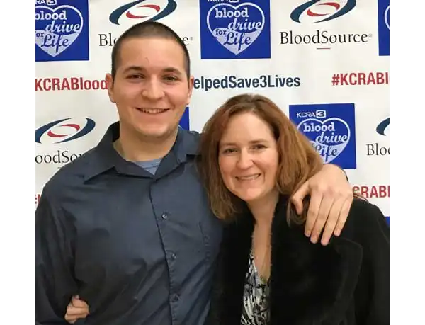 John standing with his arm around his mother
