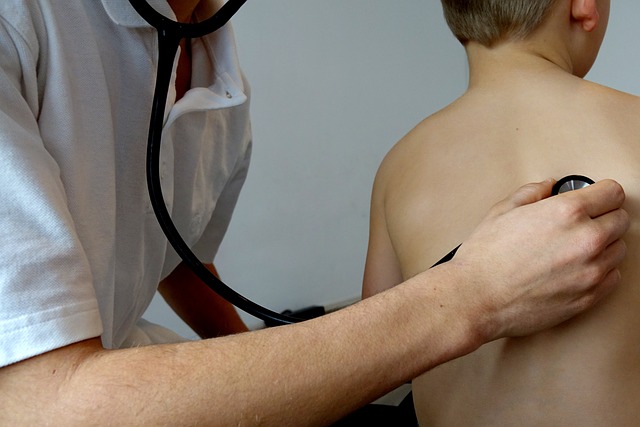 Doctor with stethoscope on child's back