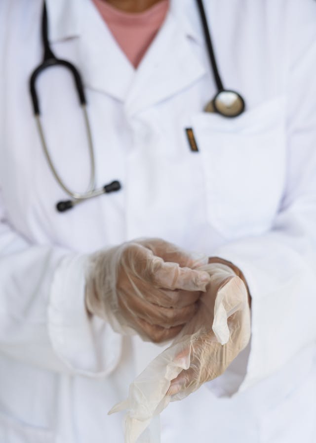 Doctor putting on plastic gloves