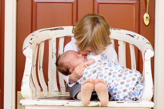 Toddler kissing infant