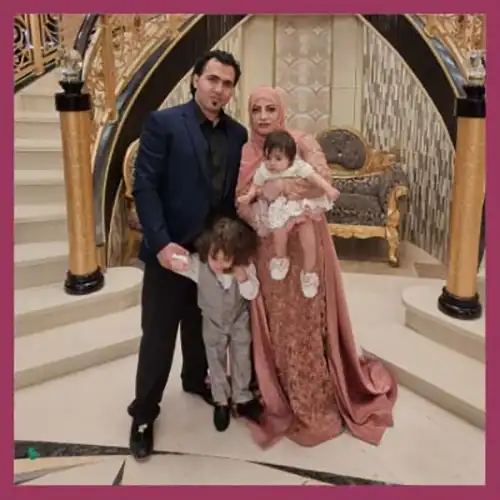Fatema standing with her husband and two children