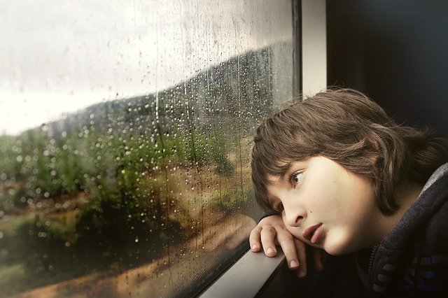 Tired child looking out window